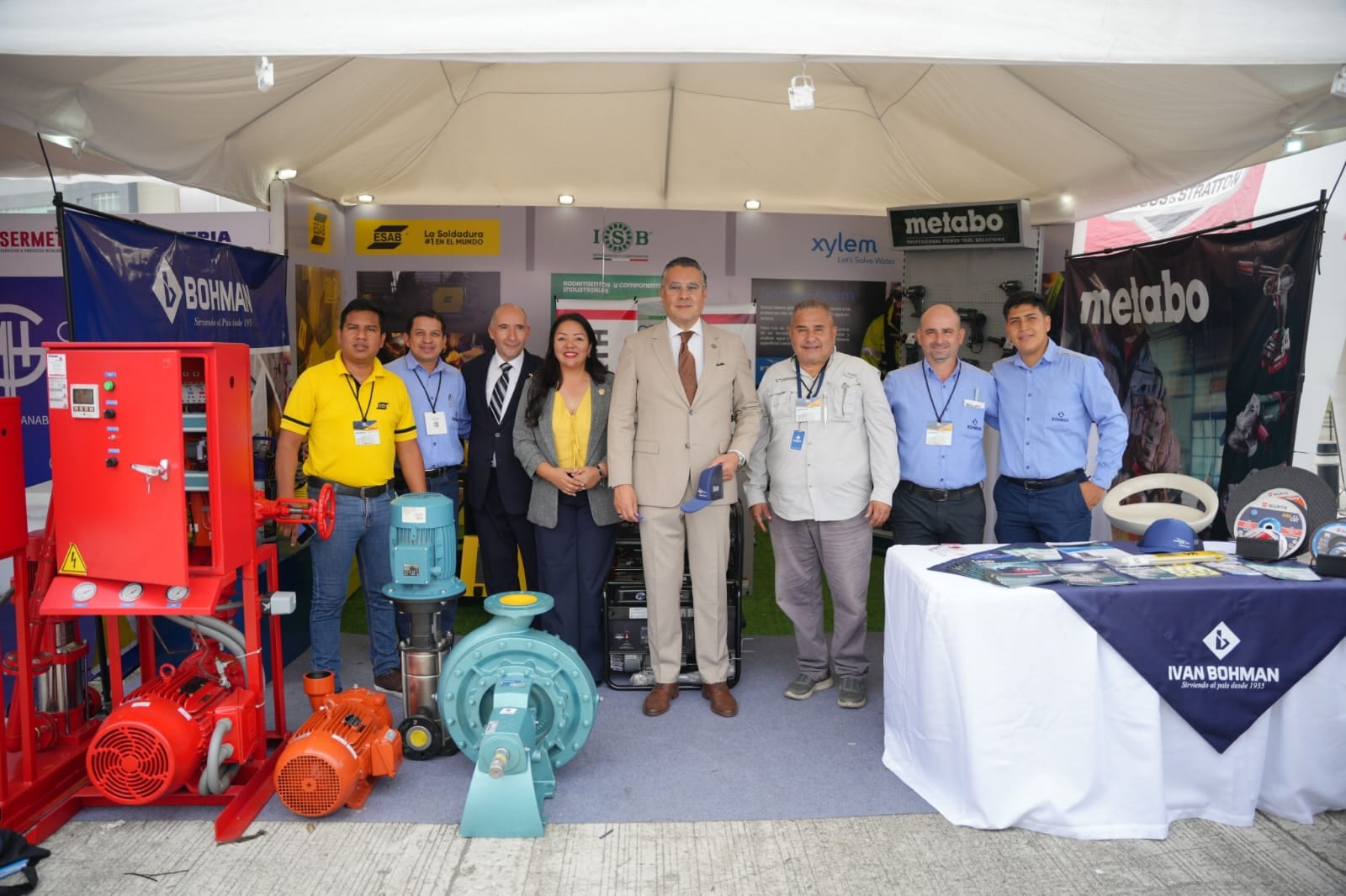 Equipo y expositores en stand de EXPOMAQSER con maquinaria industrial